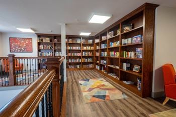 A library with wooden shelves and a staircase